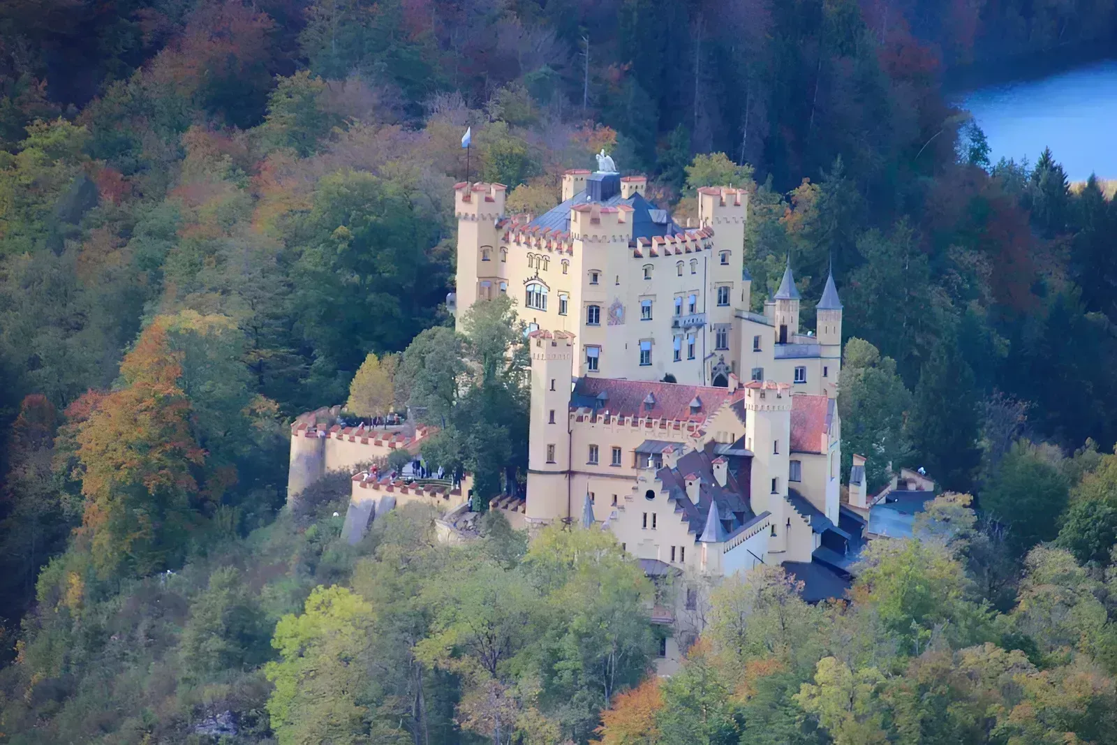 a large castle sitting on top of a lush green hillside