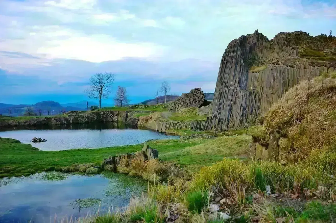 A dramatic elevated view across Czech terrain that captures both wild nature and nearby settlements.